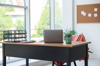 Photo of Home workspace. Modern laptop and stationery on wooden desk indoors