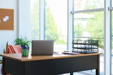 Photo of Home workspace. Modern laptop and stationery on wooden desk indoors