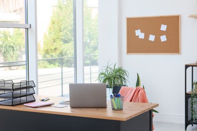 Photo of Home workspace. Modern laptop and stationery on wooden desk indoors