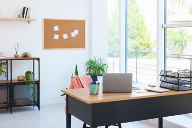 Photo of Home workspace. Modern laptop and stationery on wooden desk indoors