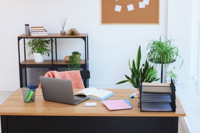 Photo of Home workspace. Modern laptop and stationery on wooden desk indoors