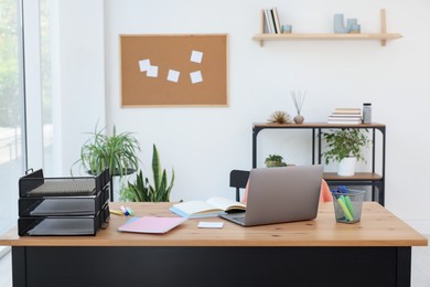 Photo of Home workspace. Modern laptop and stationery on wooden desk indoors