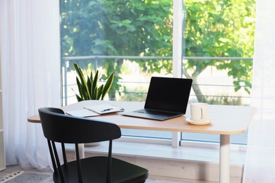 Photo of Home workspace. Modern laptop and stationery on wooden desk indoors