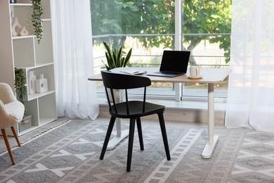 Photo of Home workspace. Modern laptop and stationery on wooden desk indoors