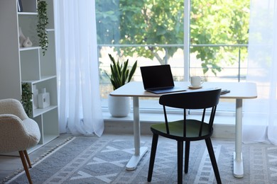 Photo of Home workspace. Modern laptop and stationery on wooden desk indoors