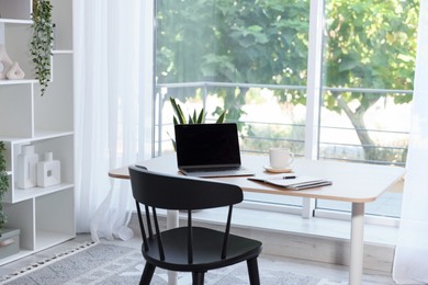 Photo of Home workspace. Modern laptop and stationery on wooden desk indoors