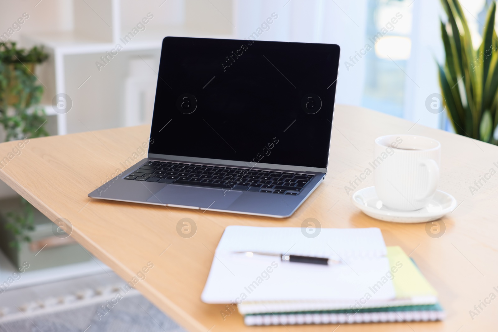 Home workspace. Modern laptop and stationery on wooden desk indoors Photo of Home workspace. Modern laptop and stationery on wooden desk indoors