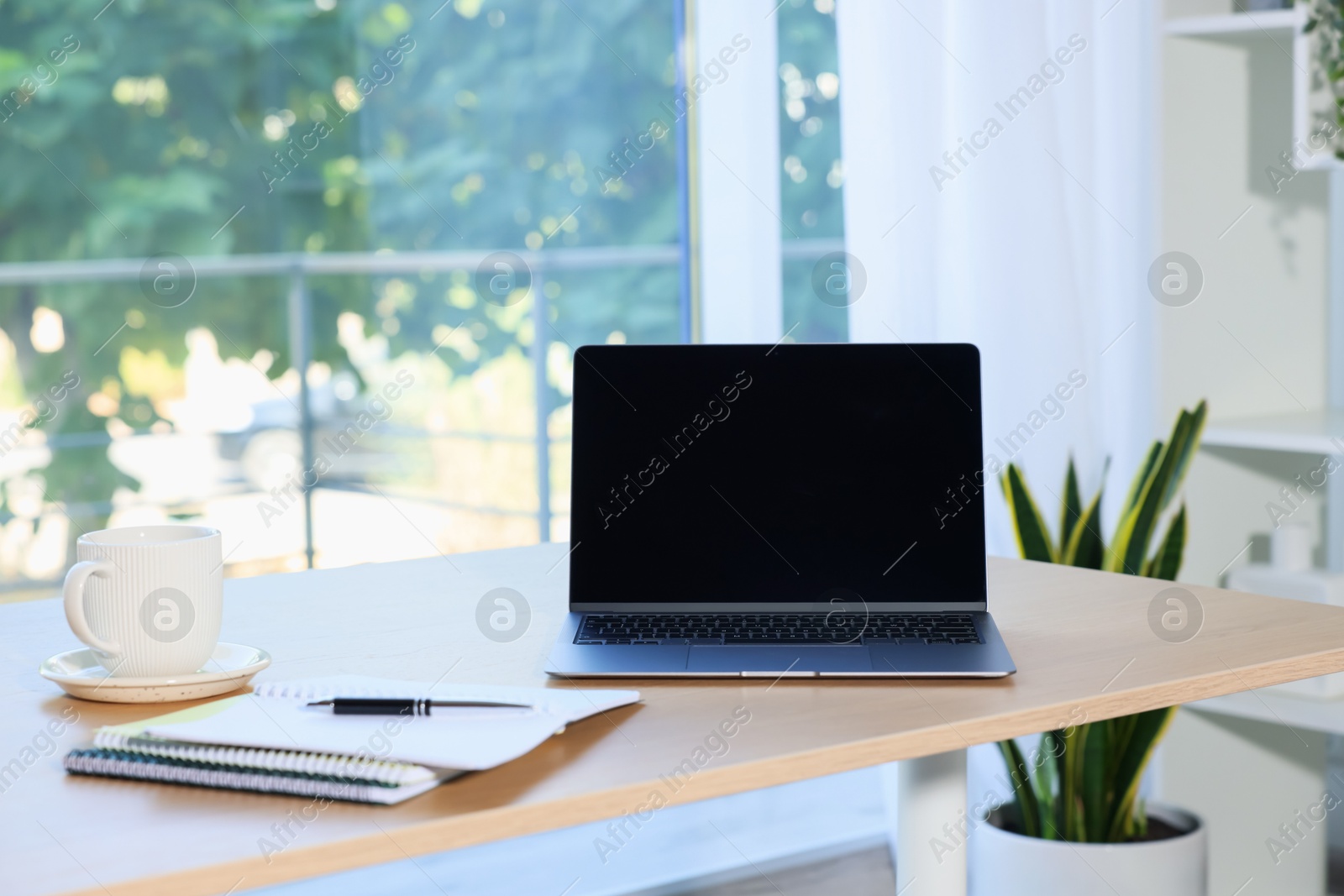 Photo of Home workspace. Modern laptop and stationery on wooden desk indoors