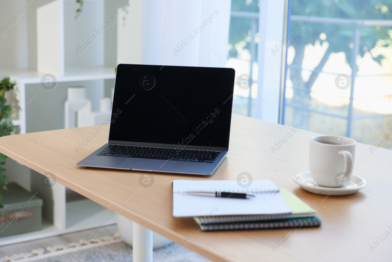 Photo of Home workspace. Modern laptop and stationery on wooden desk indoors