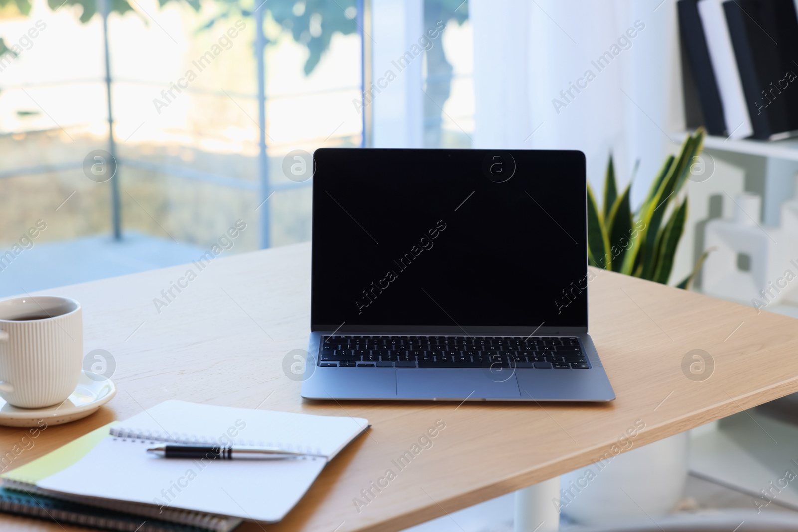 Photo of Home workspace. Modern laptop and stationery on wooden desk indoors
