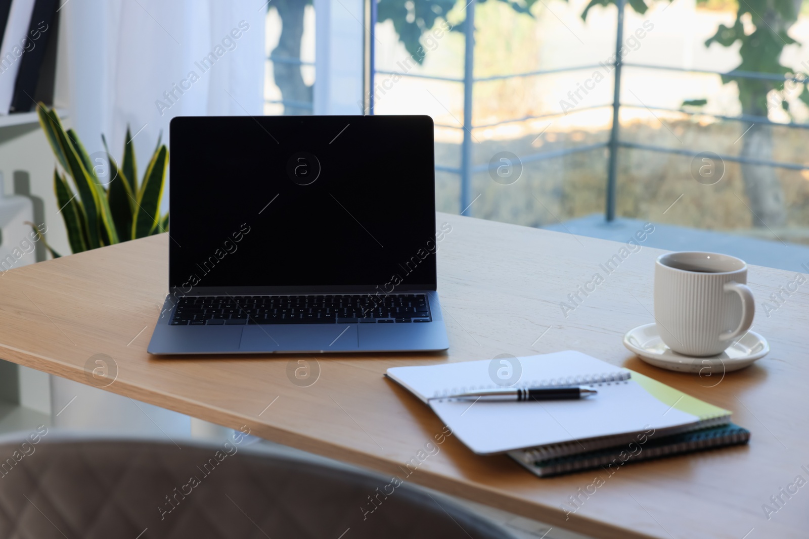 Photo of Home workspace. Modern laptop and stationery on wooden desk indoors