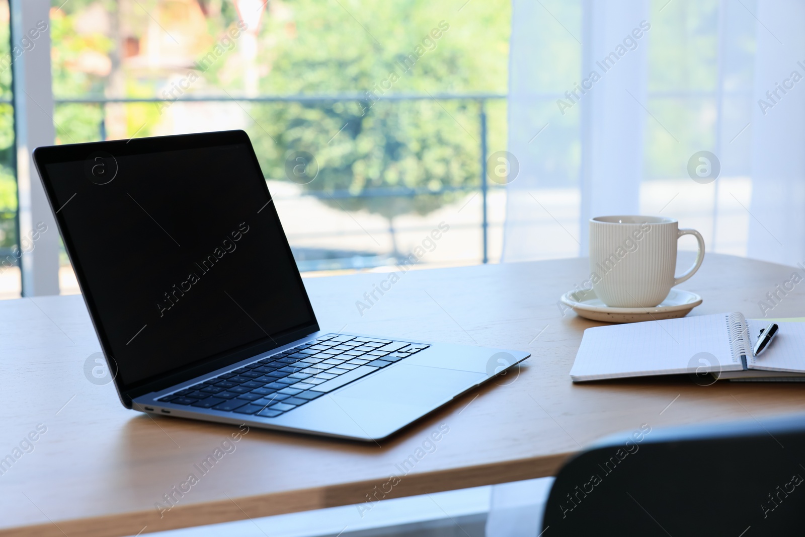 Home workspace. Modern laptop and stationery on wooden desk indoors Photo of Home workspace. Modern laptop and stationery on wooden desk indoors