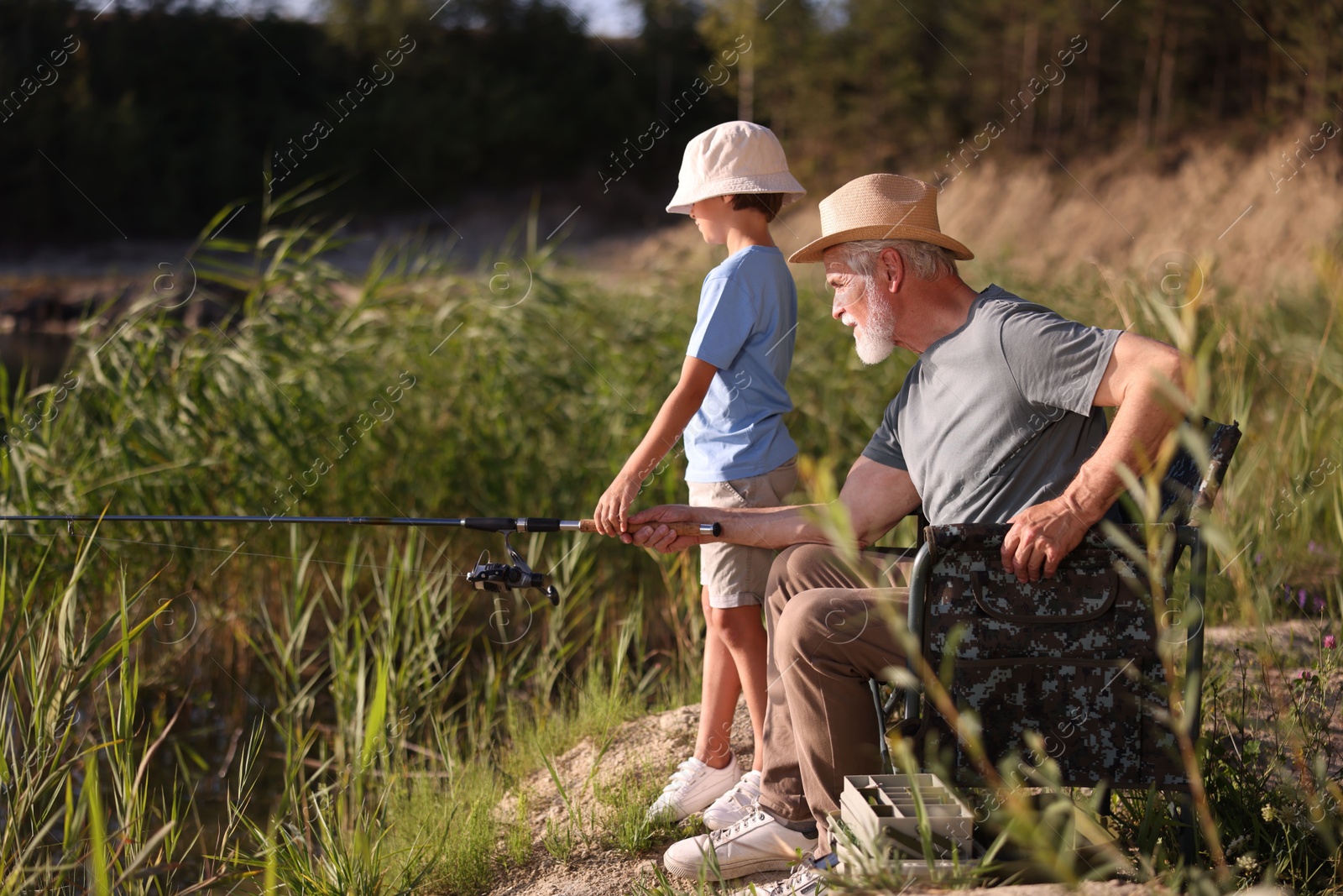 Grandfather and his nephew fishing together outdoors Photo of Grandfather and his nephew fishing together outdoors