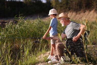 Photo of Grandfather and his nephew fishing together outdoors