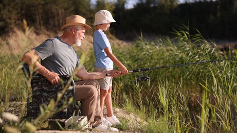 Photo of Grandfather and his nephew fishing together outdoors