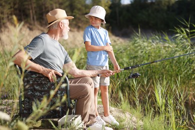 Photo of Grandfather and his nephew fishing together outdoors