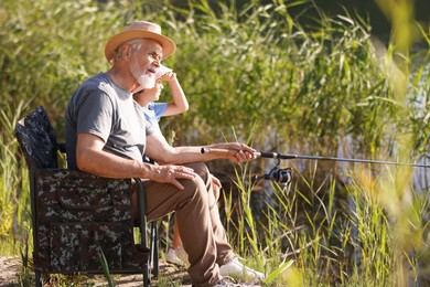 Photo of Grandfather and his nephew fishing together outdoors