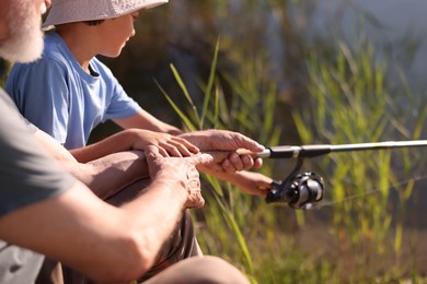 Photo of Grandfather and his nephew fishing together outdoors, closeup