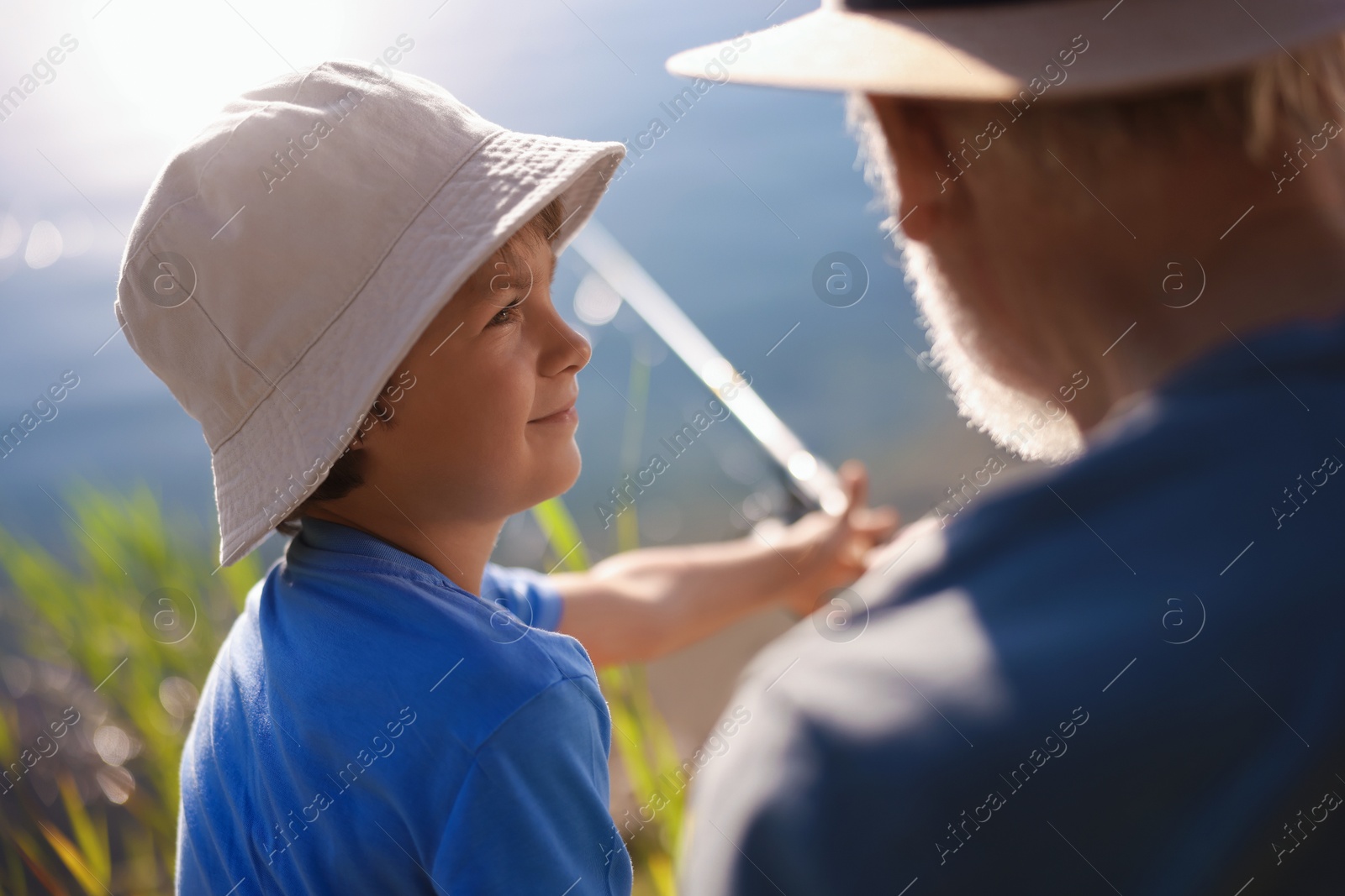 Photo of Grandfather and his nephew fishing together outdoors, closeup