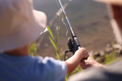 Photo of Grandfather and his nephew fishing together outdoors, closeup