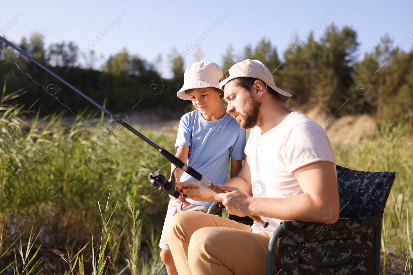 Father and his little son fishing together outdoors Photo of Father and his little son fishing together outdoors