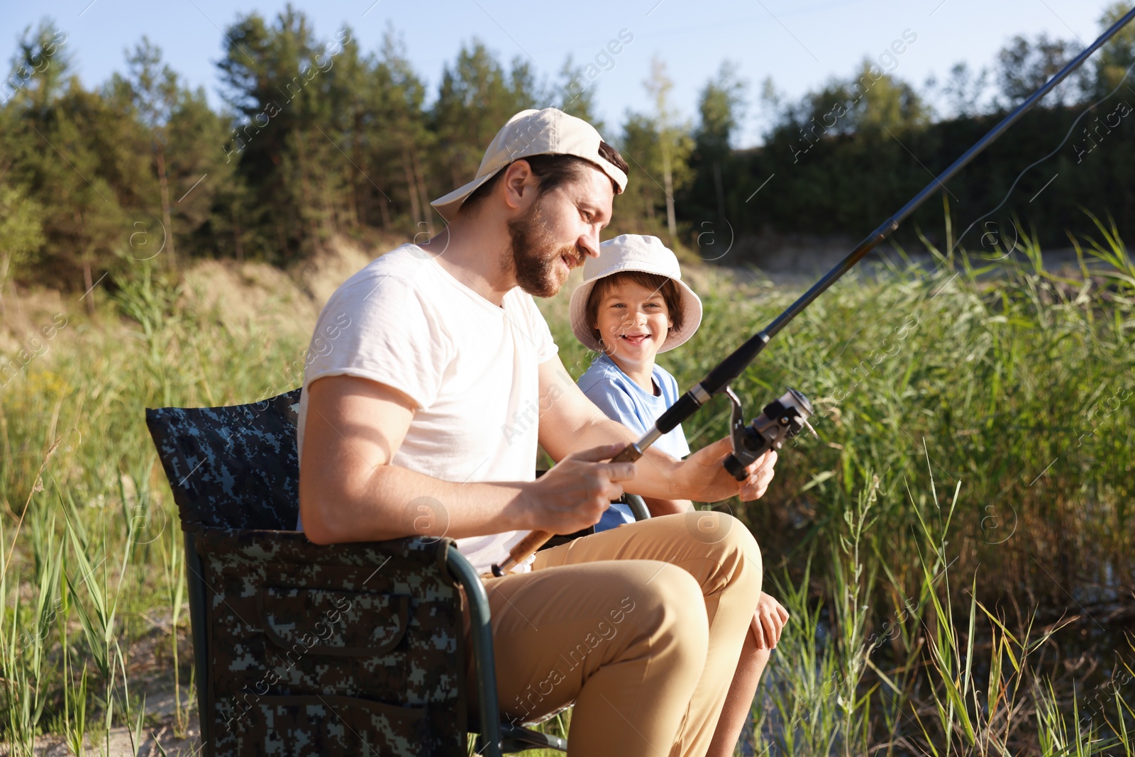 Father and his little son fishing together outdoors Photo of Father and his little son fishing together outdoors