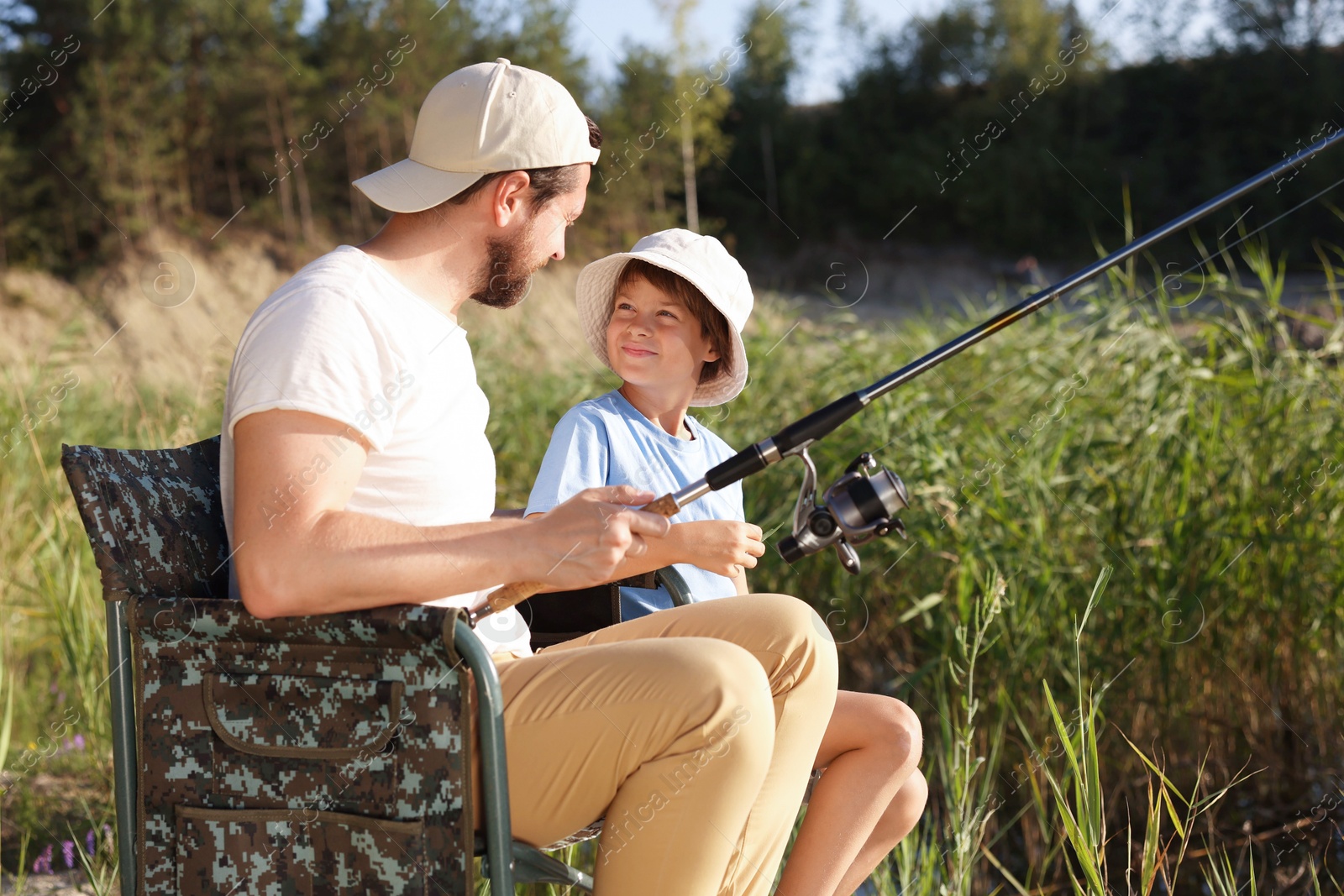 Father and his little son fishing together outdoors Photo of Father and his little son fishing together outdoors