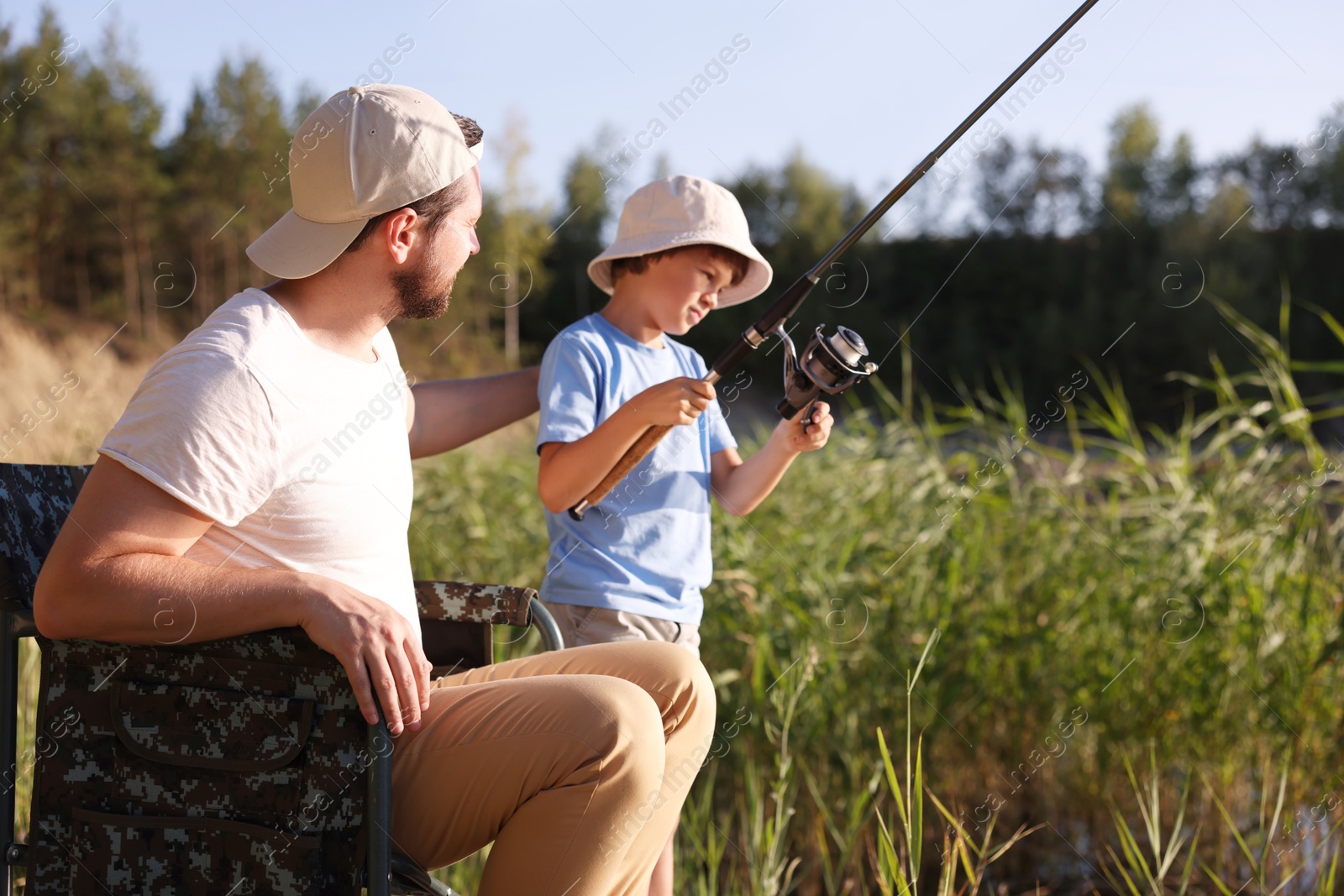 Father and his little son fishing together outdoors Photo of Father and his little son fishing together outdoors