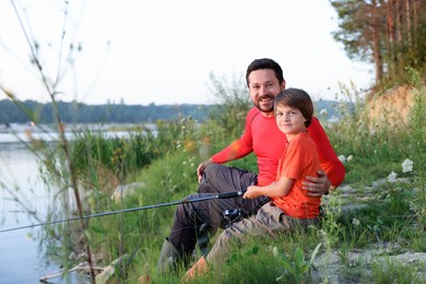 Photo of Happy father and his little son fishing together outdoors