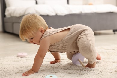 Photo of Cute baby crawling on floor at home