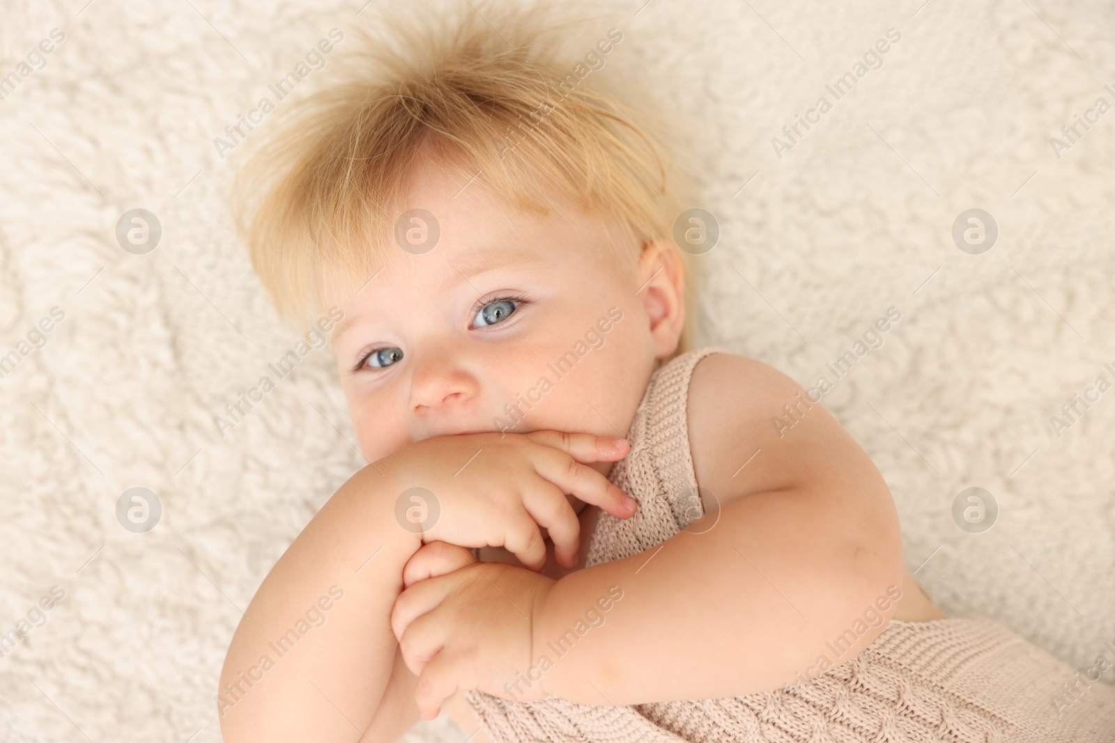 Cute baby lying on beige carpet at home, top view Photo of Cute baby lying on beige carpet at home, top view