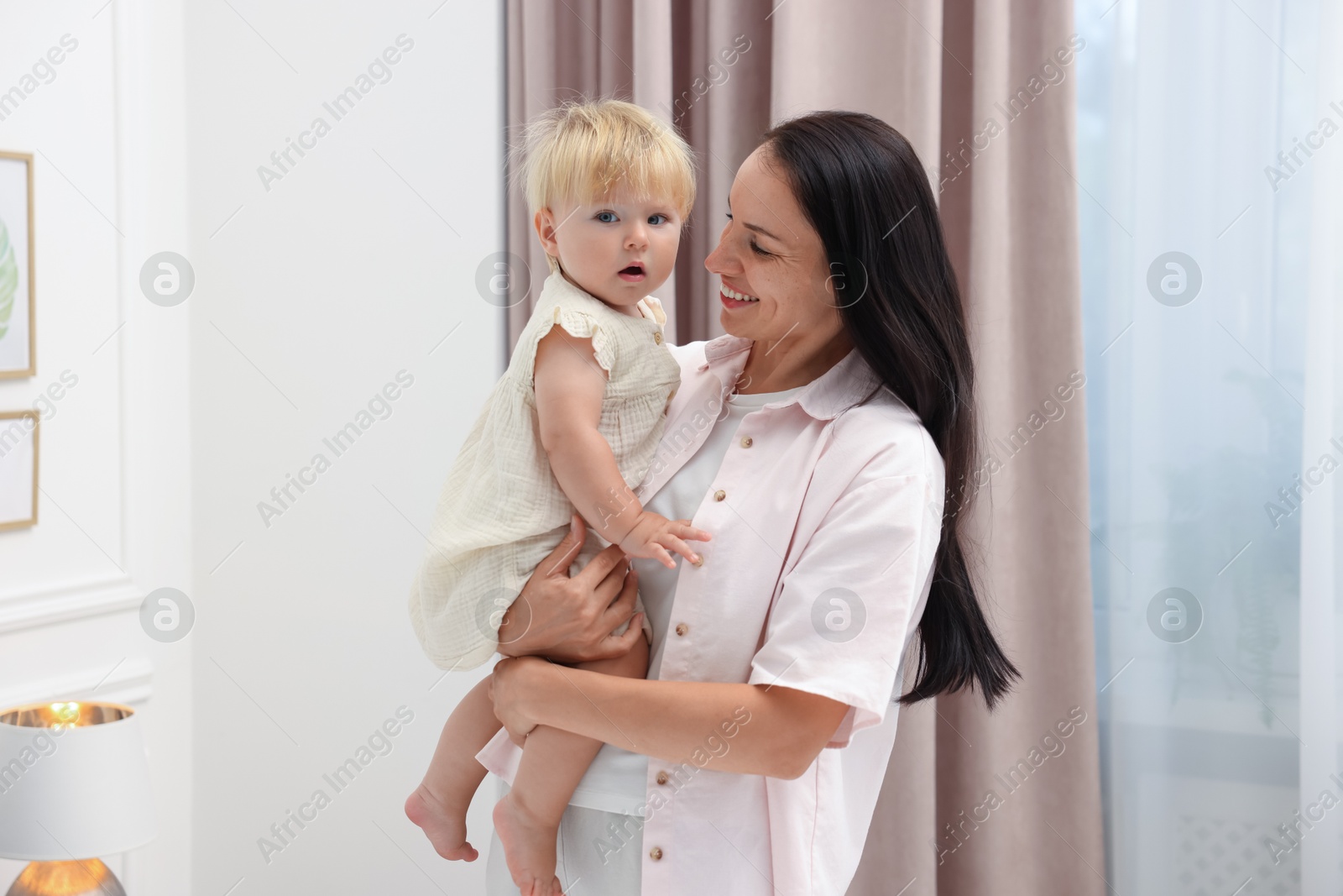 Smiling mother with her cute baby girl at home Photo of Smiling mother with her cute baby girl at home