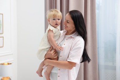 Photo of Smiling mother with her cute baby girl at home