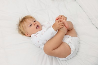 Photo of Cute baby lying on bed at home