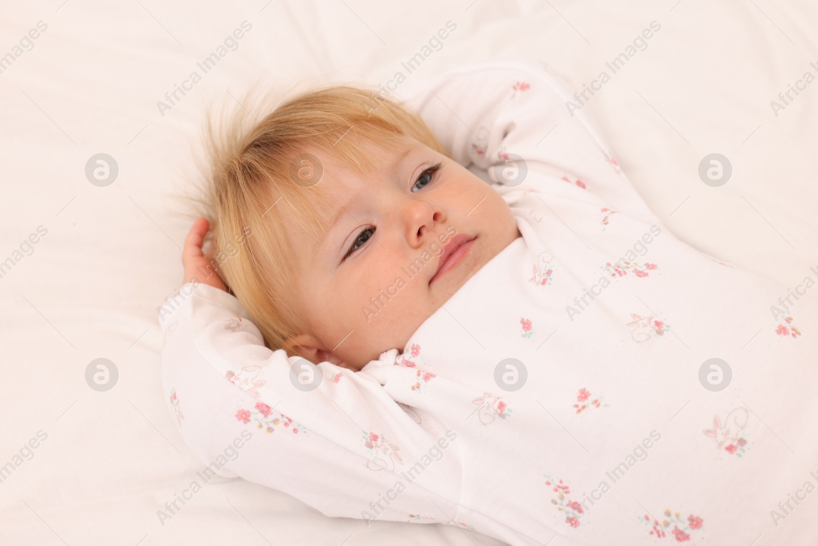 Cute baby lying on bed at home, closeup Photo of Cute baby lying on bed at home, closeup