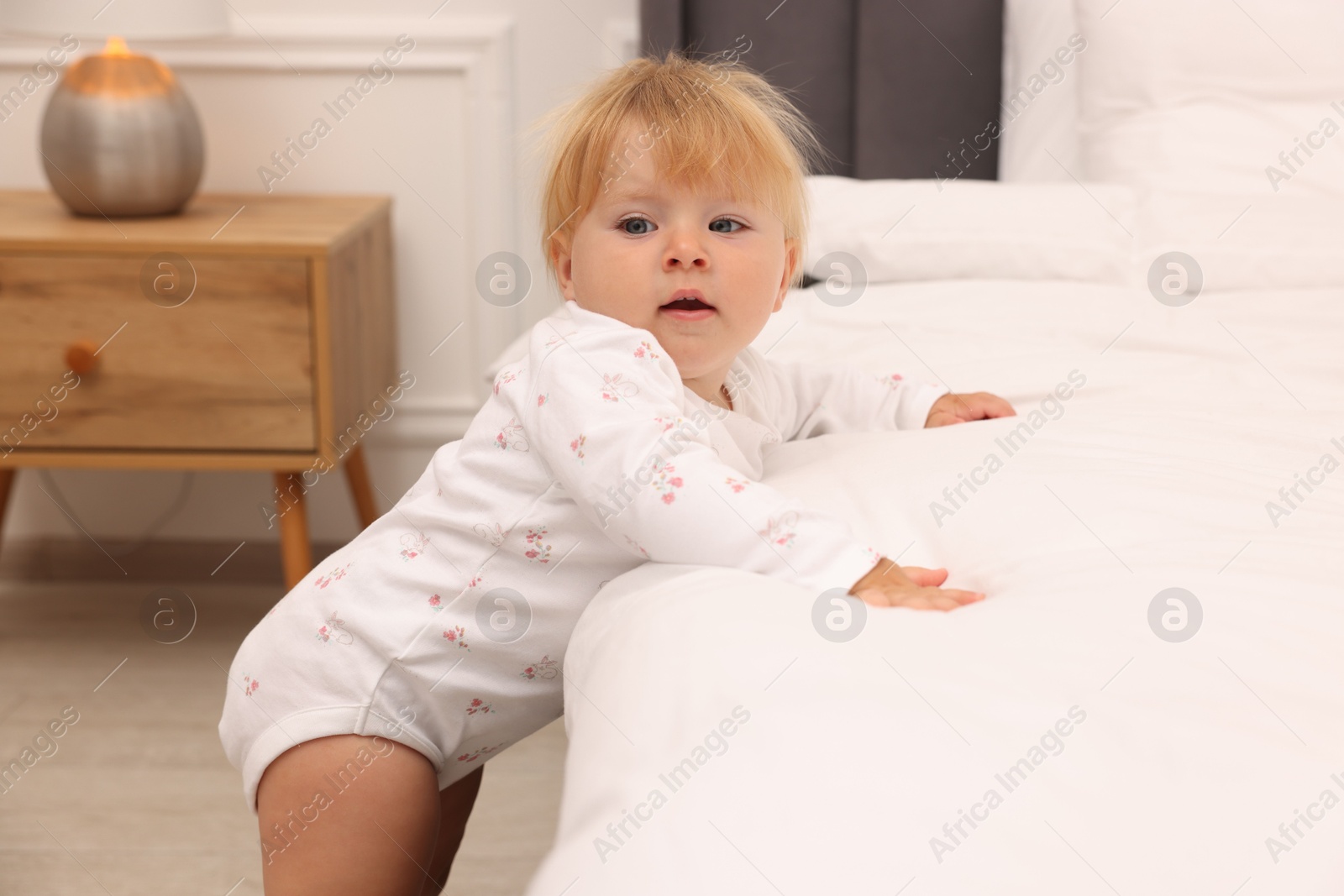 Cute baby leaning on bed at home Photo of Cute baby leaning on bed at home
