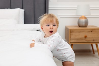 Photo of Cute baby leaning on bed at home