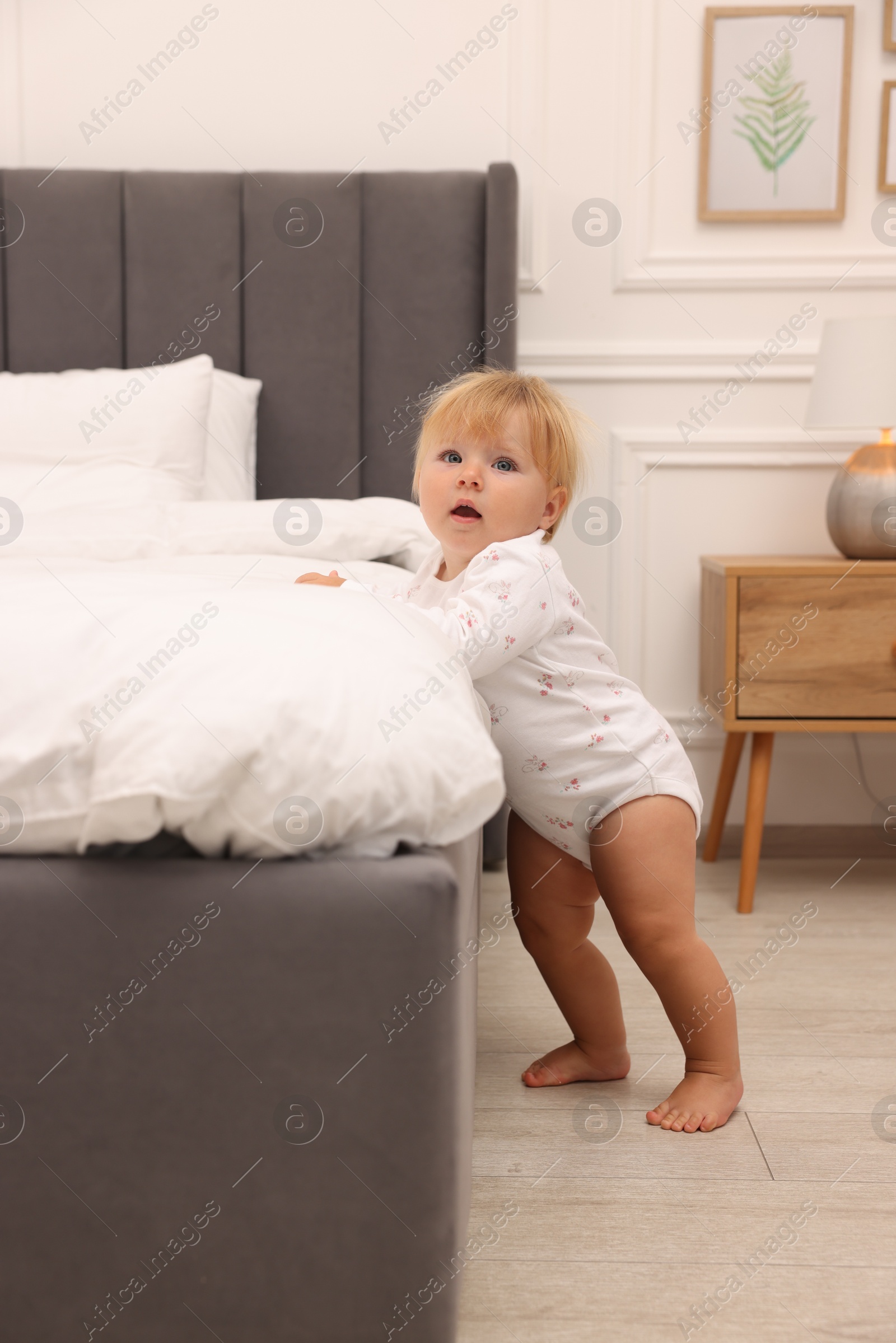 Photo of Cute baby leaning on bed at home