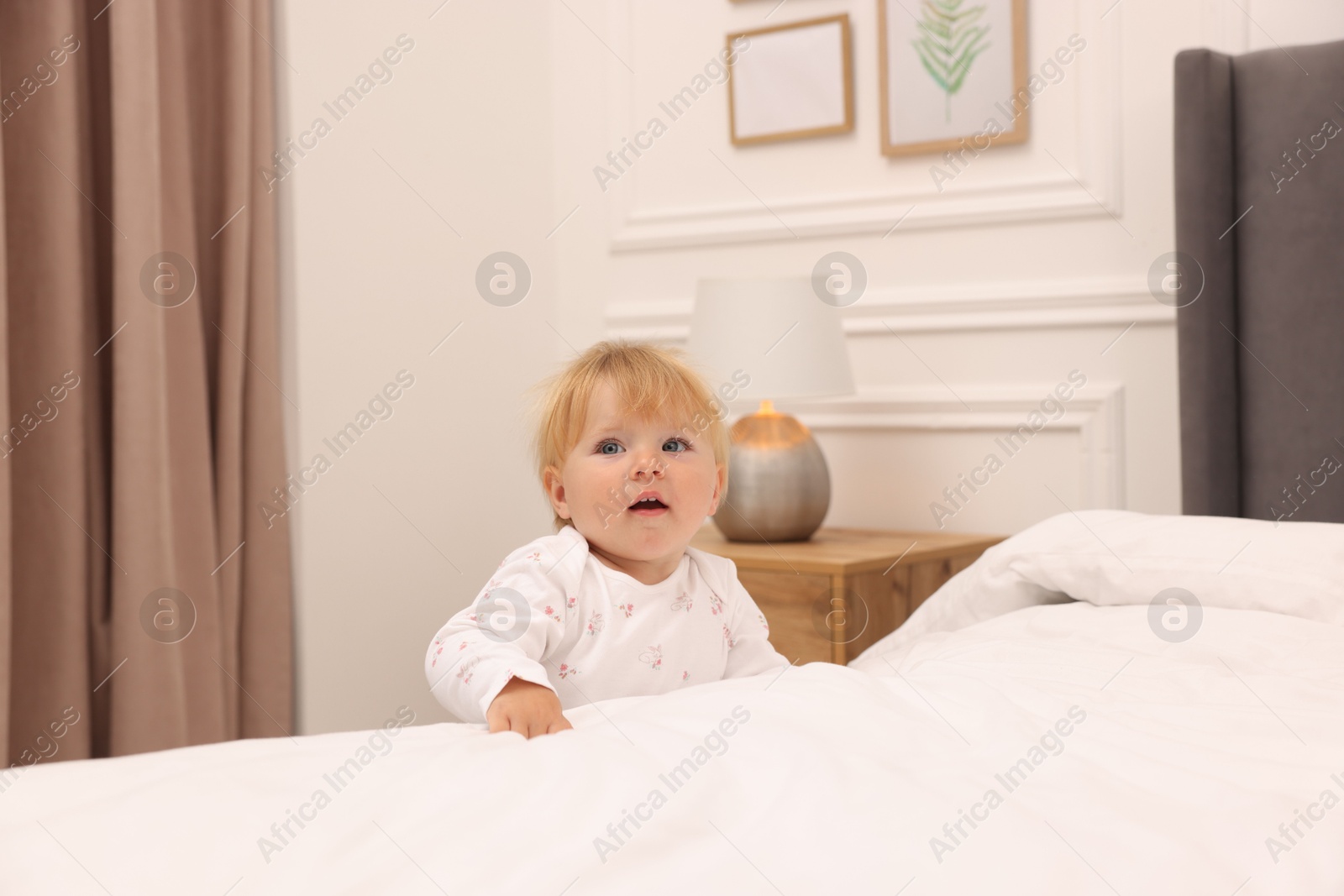 Photo of Cute baby leaning on bed at home