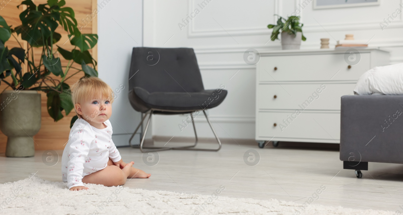 Cute baby sitting on floor at home. Space for text Photo of Cute baby sitting on floor at home. Space for text
