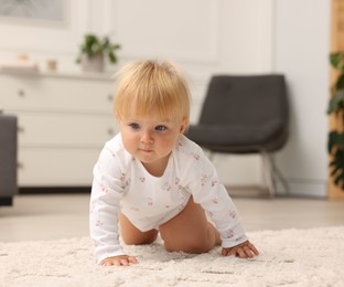 Photo of Cute baby crawling on floor at home