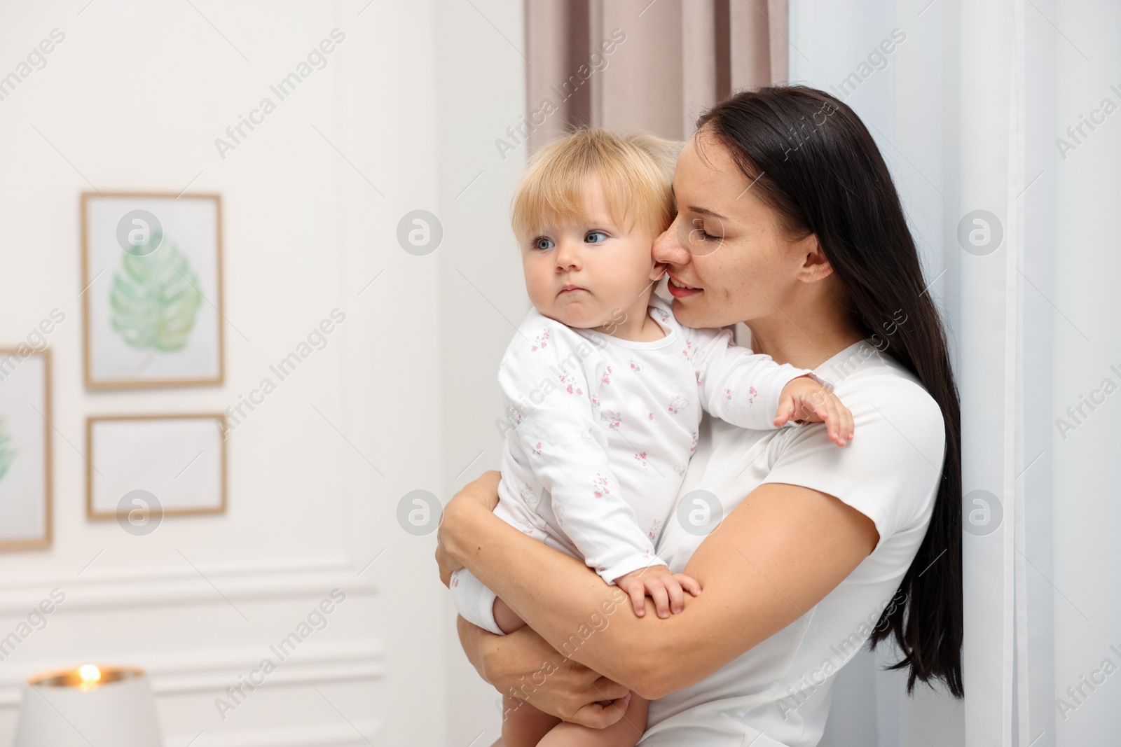 Smiling mother hugging her cute baby at home. Space for text Photo of Smiling mother hugging her cute baby at home. Space for text