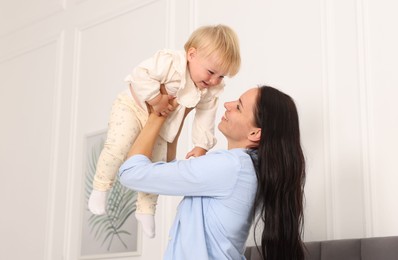 Photo of Smiling mother with her cute baby at home