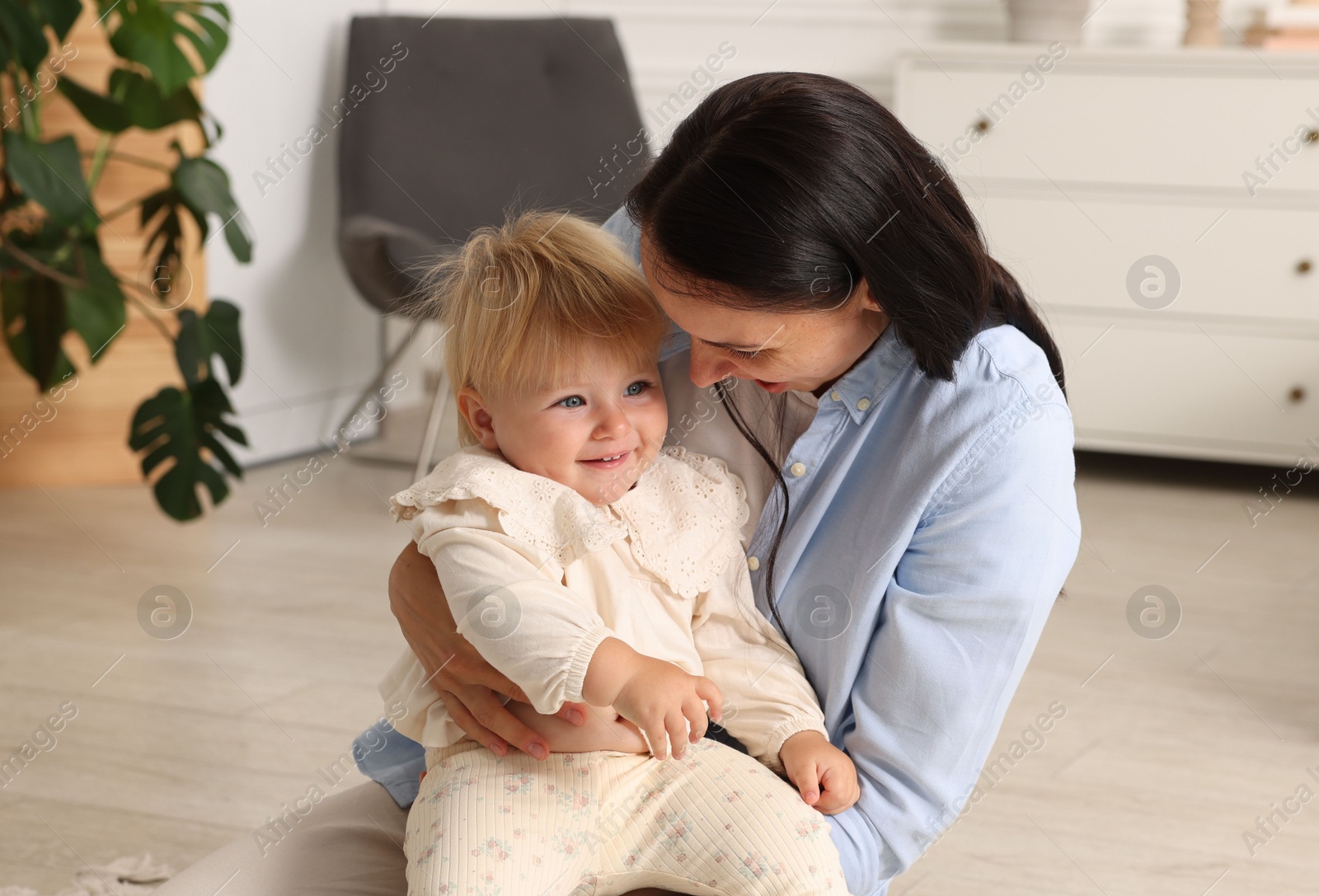 Mother with her cute baby sitting on floor at home Photo of Mother with her cute baby sitting on floor at home