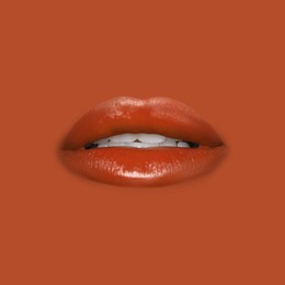 Image of Woman's lips against background matching color of her lipstick