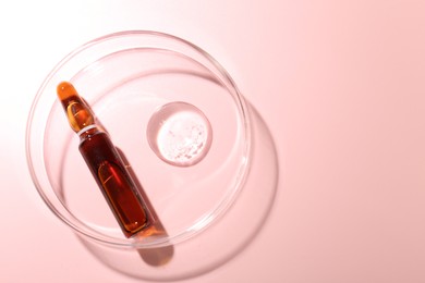 Photo of Glass ampoule with cosmetic product and Petri dish on pink background, top view. Space for text