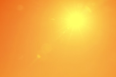 Image of Bright sun in orange sky during hot summer weather