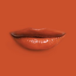 Image of Woman's lips against background matching color of her lipstick