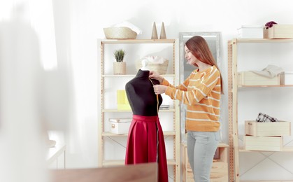 Image of Fashion designer working with mannequin in studio. Creating stylish clothes