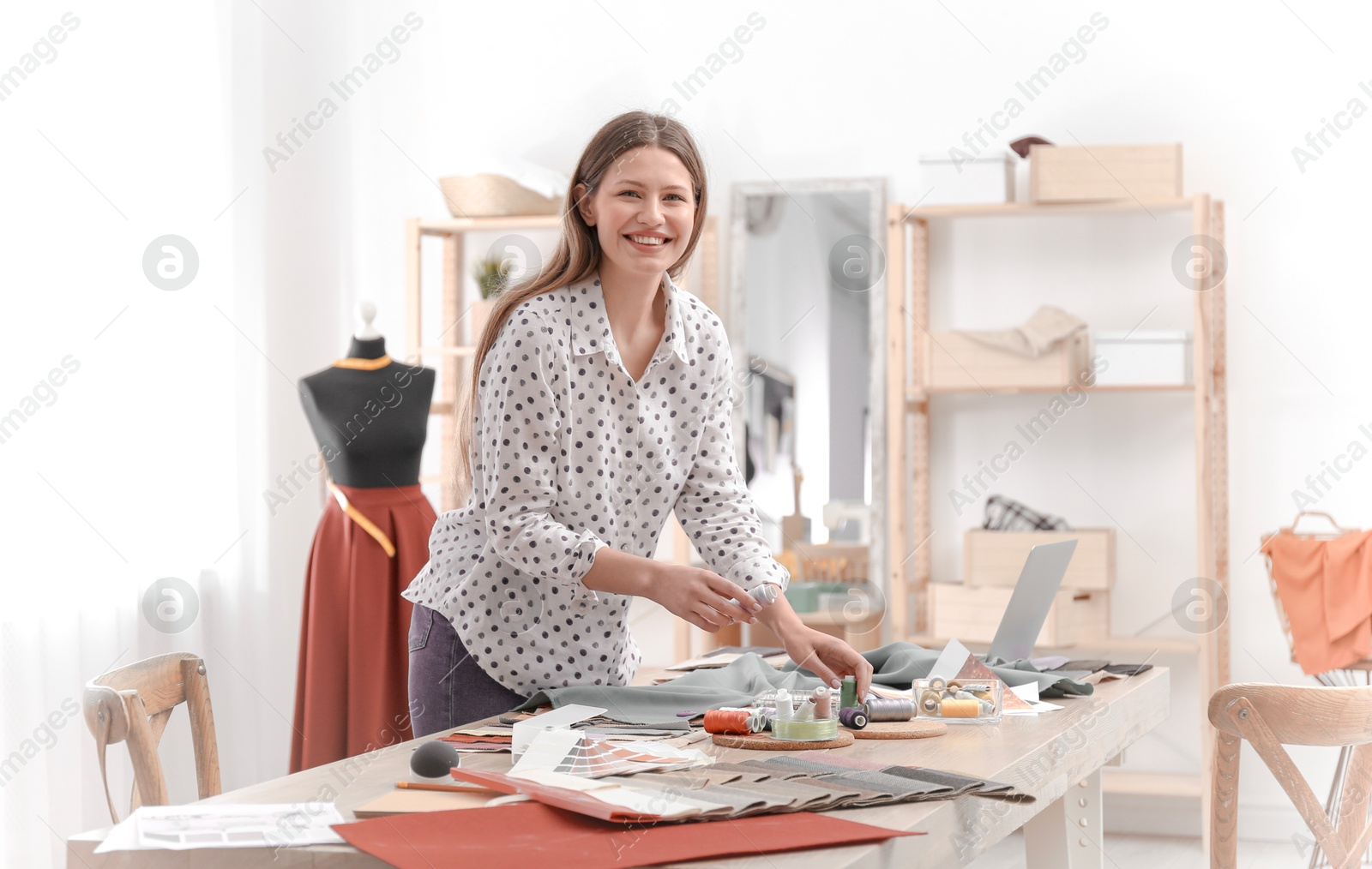 Image of Fashion designer working in her studio. Creating stylish clothes
